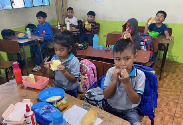 Kinder essen ihre Mahlzeit im Klassenzimmer
